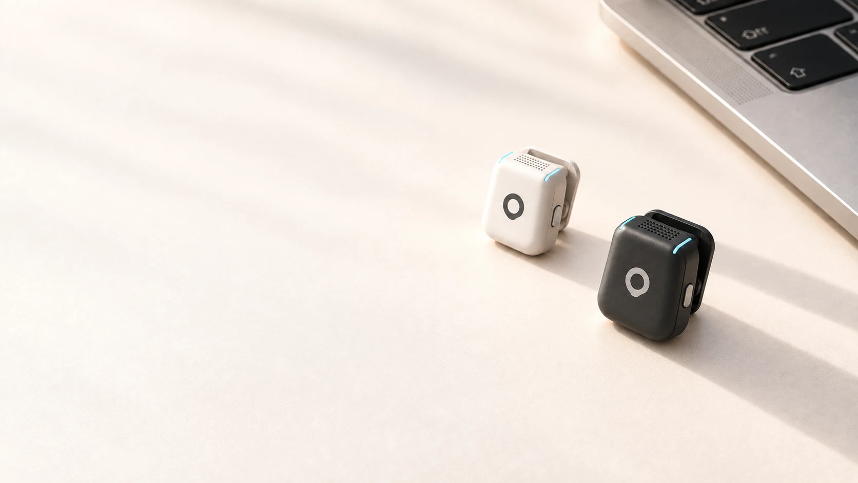 Black and white AERA microphones beside a laptop